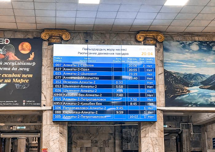 Electronic departure board showing the Almaty to Tashkent train schedule