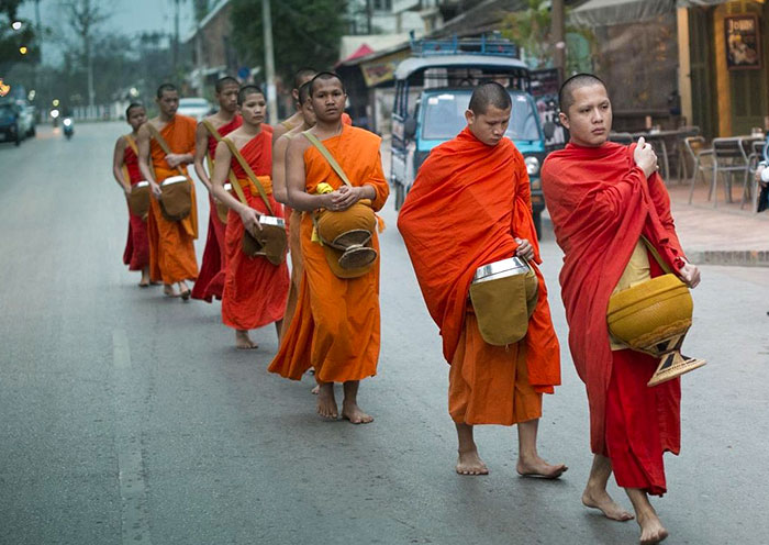 Locals provide alms to the monks for their single daily meal.