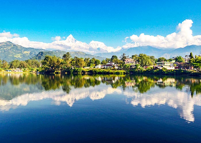 Surrounded by lush green hills and snow-capped mountains